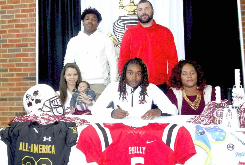 Philadelphia High School’s Lideatrick ‘Tulu’ Griffin signed with Mississippi State University on the early National signing day in December. Joining Griffin for the occasion are, seated, from left, Kaitlyn Wilson, Lichaisten Griffin, Griffin and his mother, Vneatrice Griffin; standing from left, teammate Kadarius Calloway and Philadelphia head coach David Frey.
