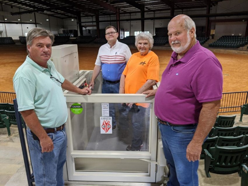 Supervisors Kevin Cumberland, left, and Keith Lillis look on as County Administrator Jeff Mayo demonstrates how the new $83,450 elevator lift at the Neshoba County Coliseum works. Work to install the lift was completed last week. Also pictured is coliseum event manager Pat McKee.