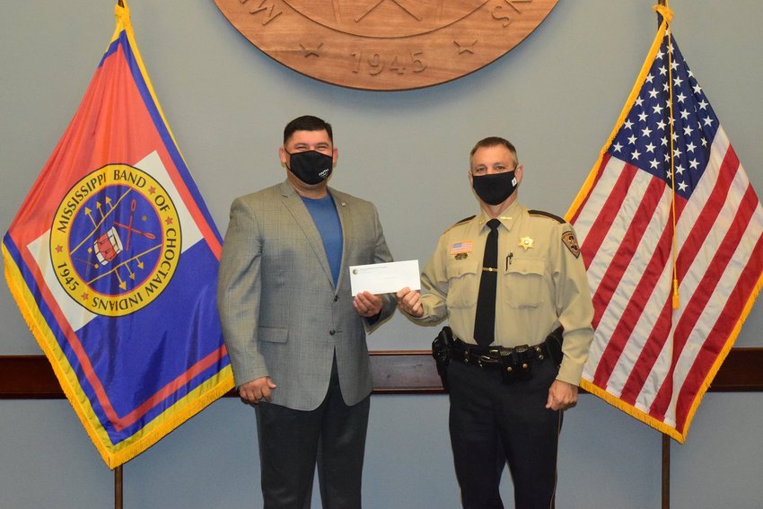 Mississippi Band of Choctaw Indians Tribal Chief Cyrus Ben presents Neshoba County Sheriff Eric Clark with a donation that will be used to purchase TASERs.