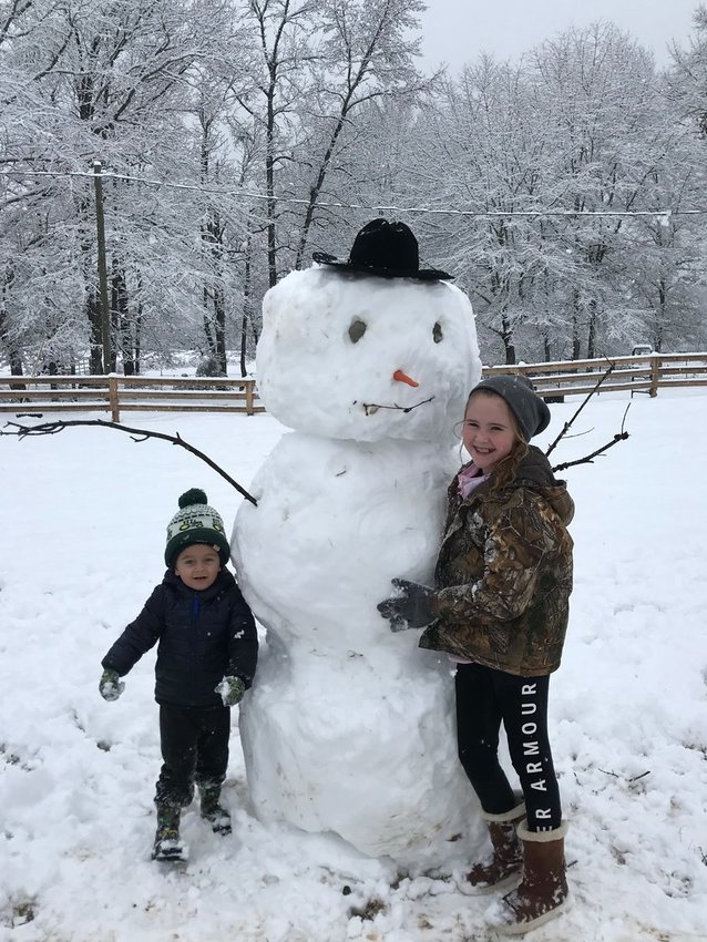 Sadie Gray and Henry Drury with a snowman in Arlington.