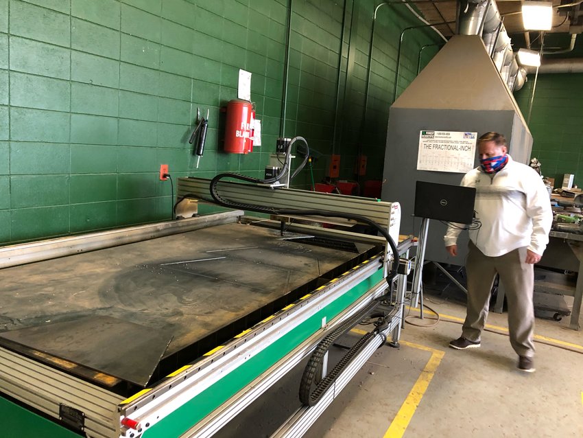 Neshoba County School District Superintendent Lundy Brantley shows off a CNC (Computer Numerical Control) laser cutter, which will be among the pieces of equipment used in the new Innovation Lab for welders to make things like fire pits.