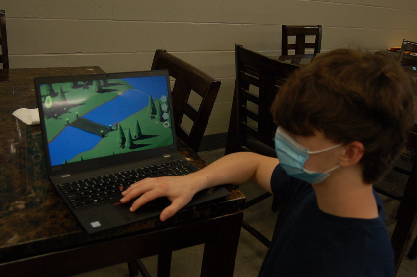 Logan Flowers shows off the video game “Appleseed” that he created.