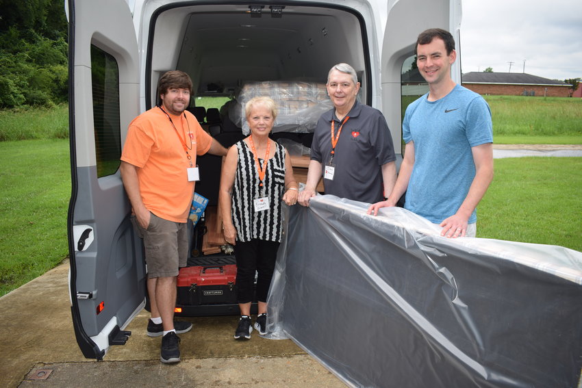 Caleb Jay, Brenda Vowell, the Rev. Dan Howard and Evan Humprhies load up a mattress.