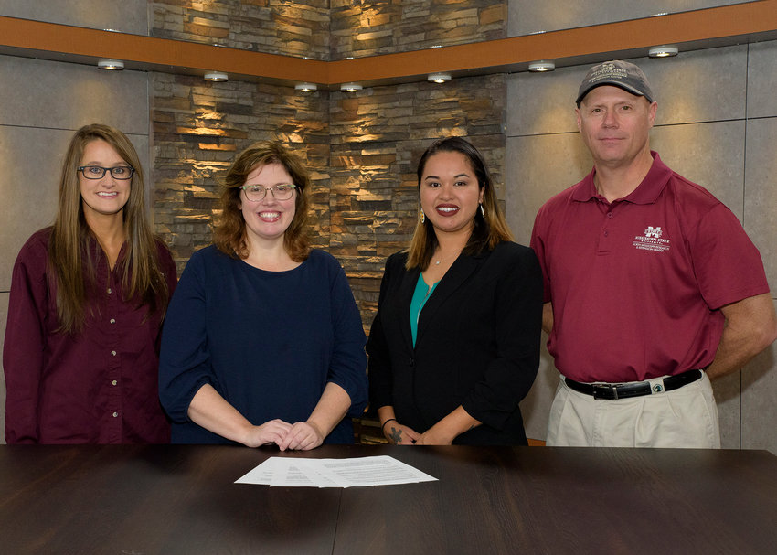 Mississippi Band of Choctaw Indians spokesperson Tia Grisham joins Mississippi State University Extension personnel Kaiti Ford, Mariah Morgan, and Jim McAdory in reviewing a memorandum of understanding that will strengthen partnerships between the tribe and MSU. .Pictured, from left: Kaiti Ford, Mariah Morgan, Tia Grisham, and Jim McArdory