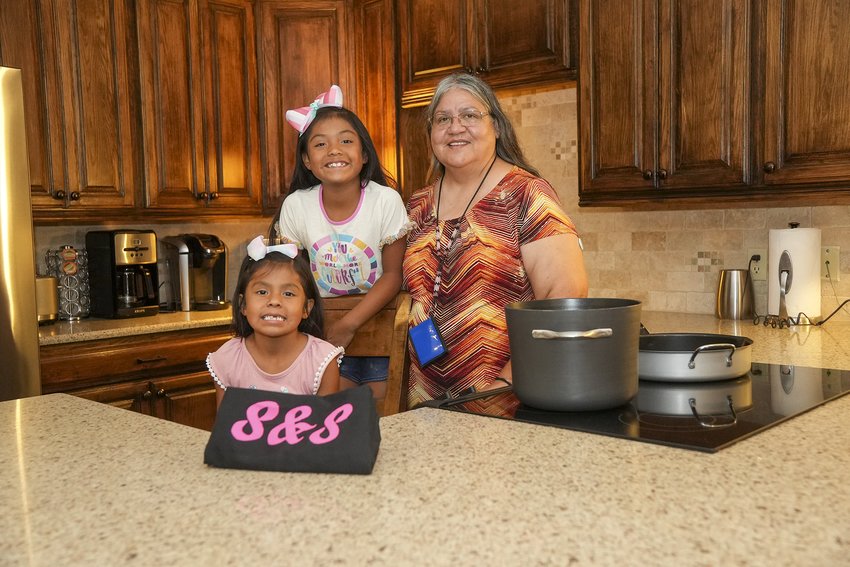 Sharron Thompson poses in the kitchen with her granddaughters Sahyimmi Isaac and Journeigh Isaac