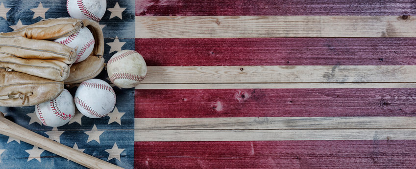 Old used baseballs, bat and glove on vintage United States wooden flag background. Baseball sports concept with copy space