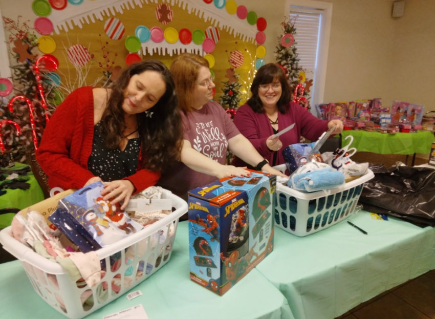 Staff members from the CPS Pregnancy and Family Resource Center Kristi McCown, Sherrie Murphy and Jennifer Nelson sort toys.