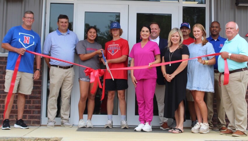 At Monday’s ribbon cutting to officially open the new baseball/softball field house at Neshoba Central are, from left, head baseball coach Jonathan Jones, athletic director Tommy Holland, softball player Lanayah Henry, baseball player Hutt Rushing, school board member Mary Ann Nicholson, superintendent of education Lundy Brantley, school board member Jill Byars, head softball coach Zach Sanders, school board member Rhonda Holley, assistant principal Lashon Horne and school board member Jimmy Joyner.